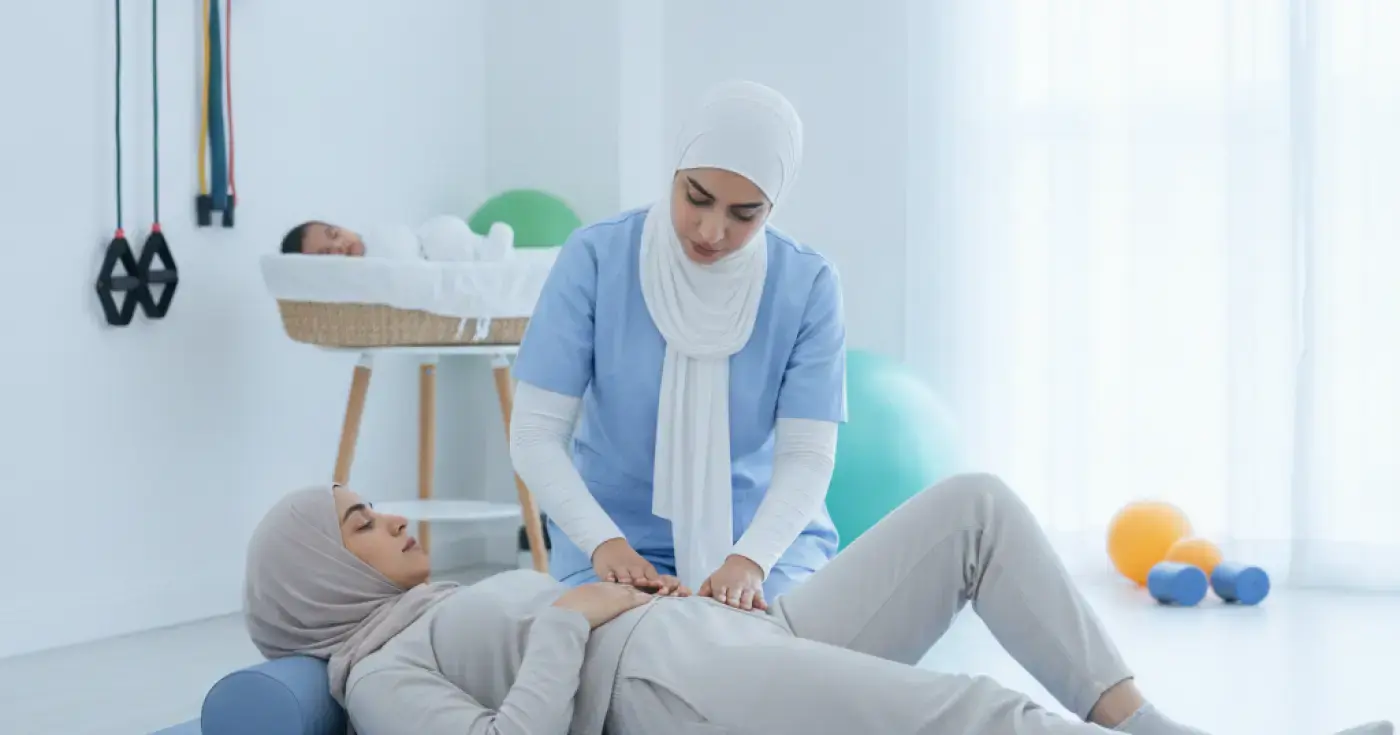 A physical therapist helping a postpartum woman perform safe pelvic floor and core exercises